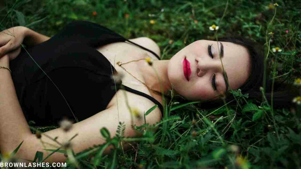 A woman sleeping peacefully on a silk pillowcase, which helps reduce eyelash breakage and promote growth.